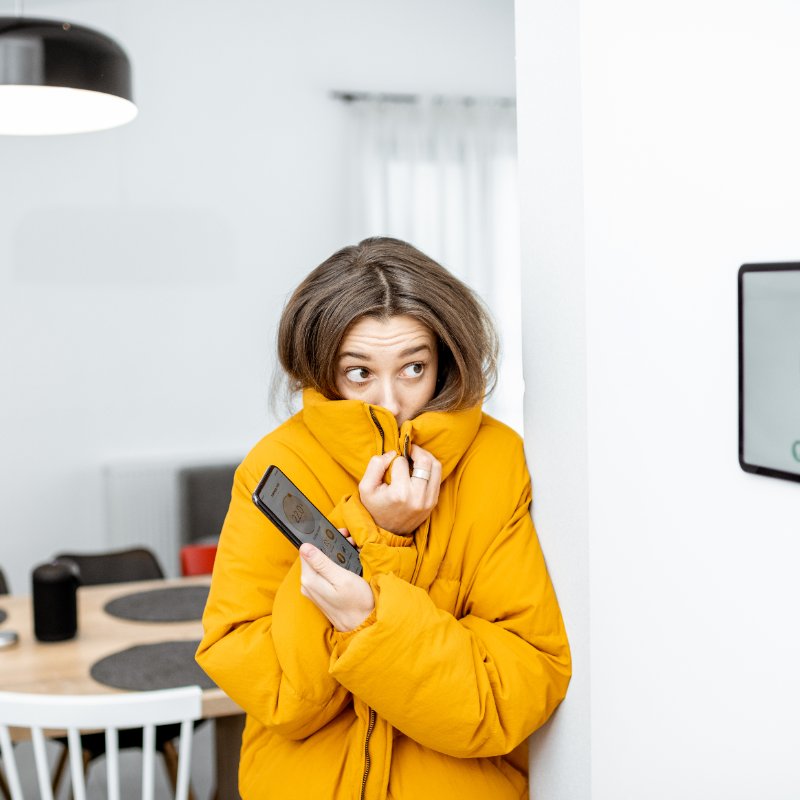 cold young woman wearing a coat indoors