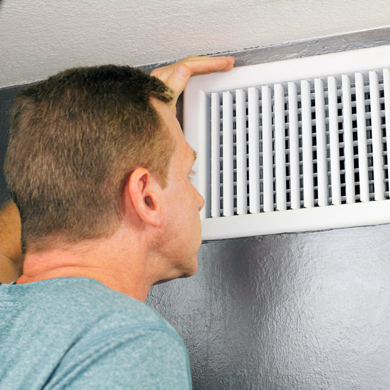 man peeking inside vent