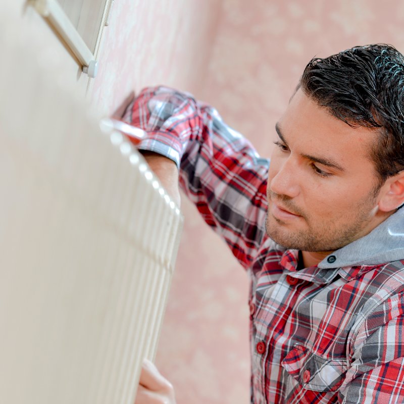 man fixing a radiator