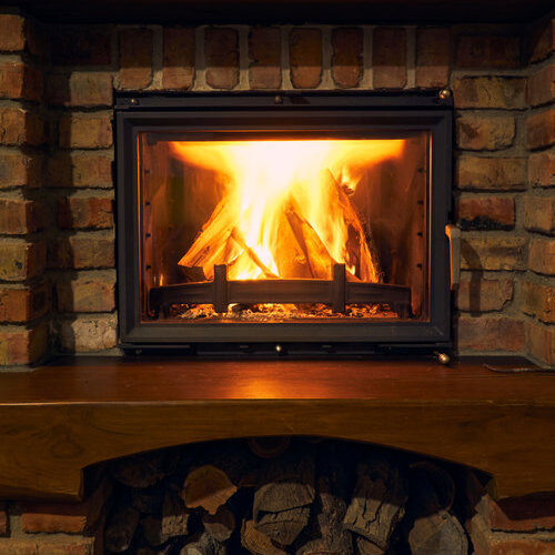 fireplace and fire close view as object or background, brick wall