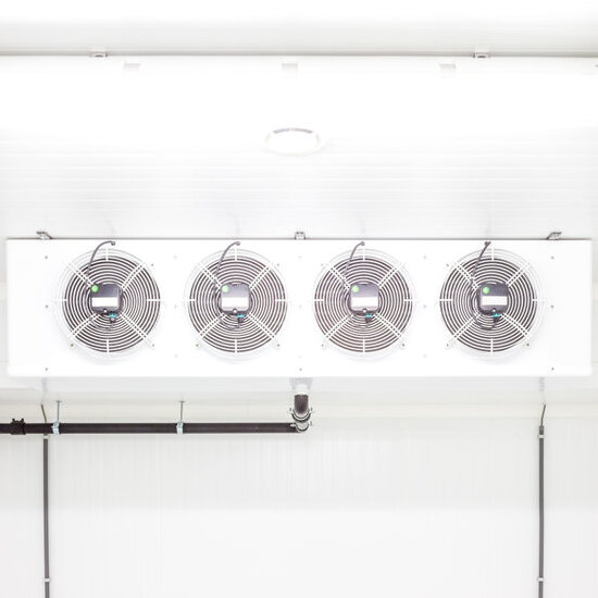 an empty industrial room refrigerator with four fans