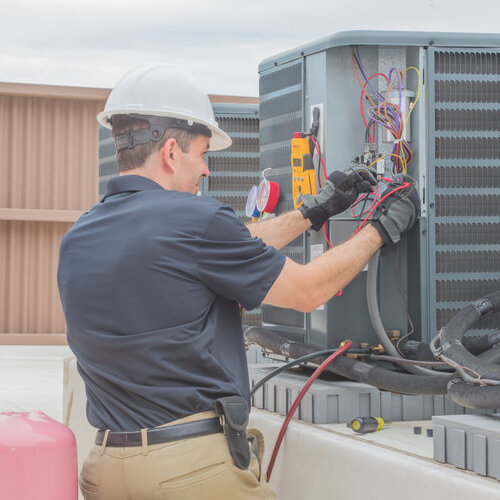 Technician checking for power on a rooftop condensing unit.