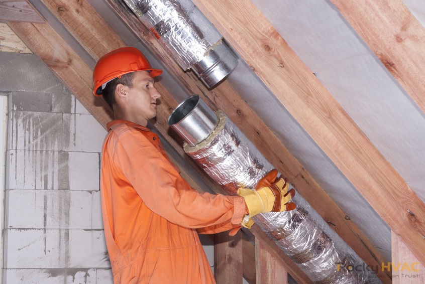 A Picture of a Man Connects Metal Air Ducts.