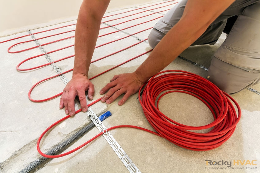 Worker installing heating cable for warm floor.