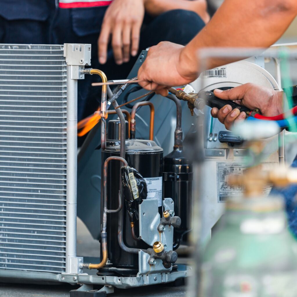 technicians injecting gases into HVAC unit